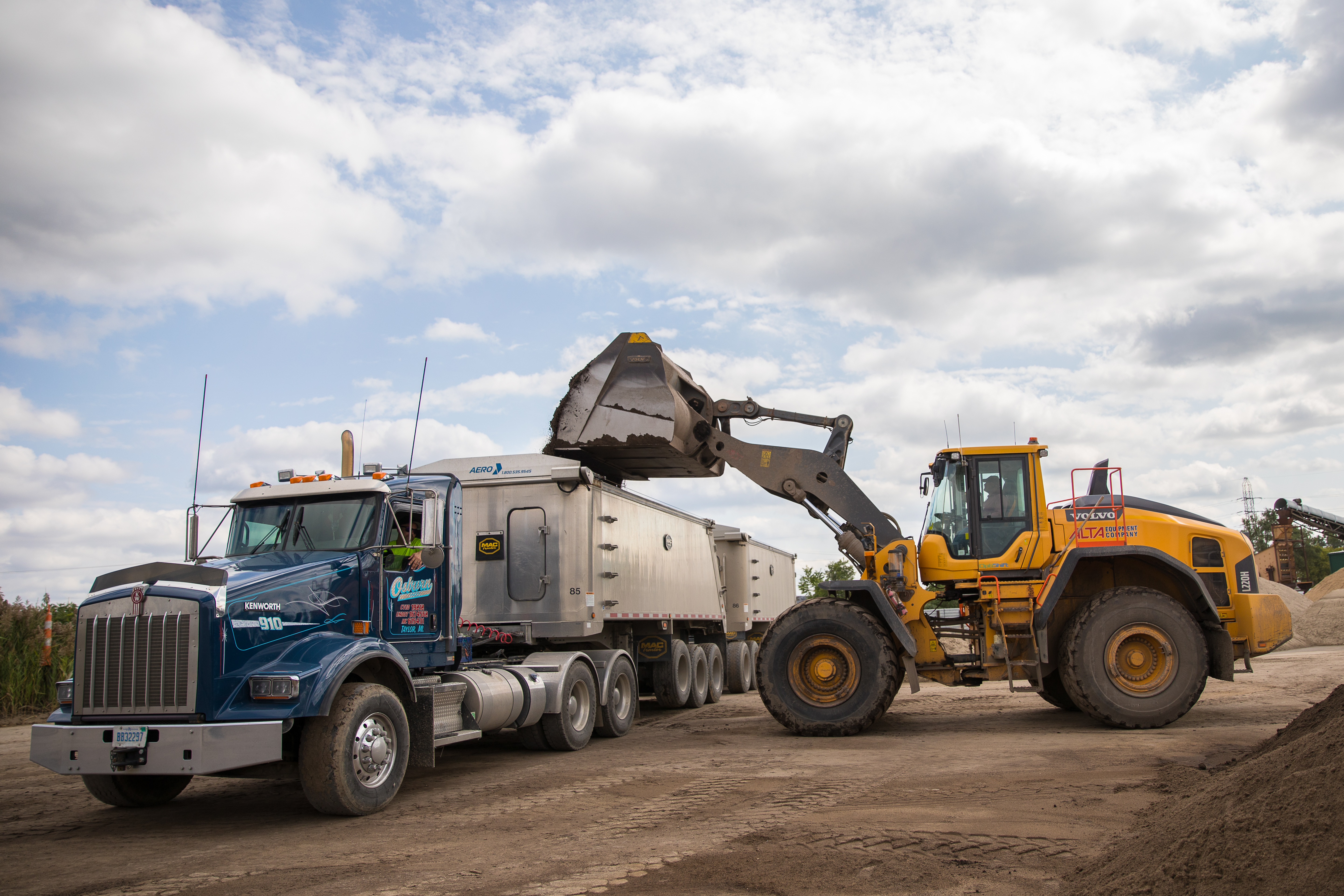 loader truck dumping into hauler